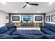 Basement living room with a large comfortable blue sectional sofa and a large entertainment center at 2656 E Oriole Dr, Gilbert, AZ 85297