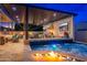 Beautiful outdoor kitchen features a gas grill, bar seating, tvs, and a connected pool with fire features at 2656 E Oriole Dr, Gilbert, AZ 85297