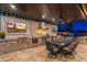 Covered outdoor kitchen equipped with a grill, sink, dining table, and a view of the pool and surrounding landscape at 2656 E Oriole Dr, Gilbert, AZ 85297