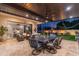 Covered patio with dining and lounge areas, an outdoor kitchen, fireplace and a view of the backyard's putting green at 2656 E Oriole Dr, Gilbert, AZ 85297