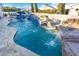 Sparkling pool featuring rock waterfall, water fountains, and a travertine tile surround at 2656 E Oriole Dr, Gilbert, AZ 85297