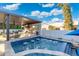 Outdoor kitchen and spa area overlooking the pool with luxurious travertine pavers at 2656 E Oriole Dr, Gilbert, AZ 85297