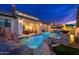 Luxury backyard showcasing a pool with water features, fire bowls, outdoor seating and mature trees with a tranquil ambiance at 2656 E Oriole Dr, Gilbert, AZ 85297