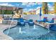 Outdoor living area features sparkling pool, cozy chairs, and luxurious travertine deck at 2656 E Oriole Dr, Gilbert, AZ 85297