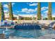 Inviting pool featuring water fountains, and a tanning shelf, set against a backdrop of mature trees and blue sky at 2656 E Oriole Dr, Gilbert, AZ 85297