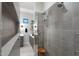 Modern tiled shower with glass door, dual shower heads, and built-in shelving for convenience at 2656 E Oriole Dr, Gilbert, AZ 85297