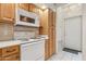 Kitchen view of white range, microwave, tiled backsplash, and wood cabinets at 320 S 70Th St # 54, Mesa, AZ 85208