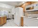 White kitchen appliances next to wood kitchen cabinets with view of the dining area at 320 S 70Th St # 54, Mesa, AZ 85208