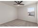 Light-filled bedroom with ceiling fan, carpet, and a large window offering backyard views at 35344 N Karan Swiss Cir, San Tan Valley, AZ 85143