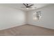 A bright bedroom with a ceiling fan, plush carpet and natural light from a window at 35344 N Karan Swiss Cir, San Tan Valley, AZ 85143