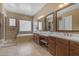 Bathroom featuring dual sinks, soaking tub, glass shower and travertine tile at 3556 E Tiffany Way, Gilbert, AZ 85298