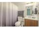 Standard bathroom with a toilet, sink, mirror, and shower with curtain at 3645 N 69Th Ave # 69, Phoenix, AZ 85033