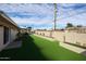 Green backyard with tall block wall for privacy featuring turf and desert landscaping at 3716 W Griswold Rd, Phoenix, AZ 85051