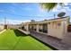 Back of home and backyard featuring synthetic lawn and covered patio at 3716 W Griswold Rd, Phoenix, AZ 85051