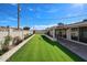 Back of home and backyard featuring synthetic lawn and covered patio at 3716 W Griswold Rd, Phoenix, AZ 85051