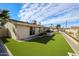 Lush backyard featuring newly installed artificial turf, desert landscaping, and a sliding glass door entry at 3716 W Griswold Rd, Phoenix, AZ 85051