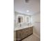 Bathroom with double vanity, quartz countertop, shaker cabinets, gold hardware, and dual, lighted mirrors at 3716 W Griswold Rd, Phoenix, AZ 85051