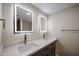 Bathroom with double vanity, quartz countertop, shaker cabinets, and dual, lighted mirrors at 3716 W Griswold Rd, Phoenix, AZ 85051