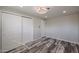Bedroom with wood-look floors, closet with sliding doors, and new lighting at 3716 W Griswold Rd, Phoenix, AZ 85051