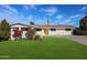 Charming single-story home features a vibrant yellow door and manicured landscaping, complete with a large driveway at 3716 W Griswold Rd, Phoenix, AZ 85051