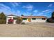 Charming single-story home features a vibrant yellow door and well-manicured landscaping, complete with a large driveway at 3716 W Griswold Rd, Phoenix, AZ 85051