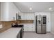 Stylish kitchen with stainless steel refrigerator, custom cabinets, and granite countertops at 3716 W Griswold Rd, Phoenix, AZ 85051