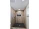 This remodeled walk-in shower features wood-look tile, black herringbone tile floor, and rainfall showerhead at 3716 W Griswold Rd, Phoenix, AZ 85051