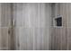 Wood-look tile inside this remodeled shower with black herringbone shower floor and shower niche at 3716 W Griswold Rd, Phoenix, AZ 85051