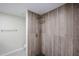Remodeled shower with wood-look tile surround and rainfall shower head and a herringbone tiled shower floor at 3716 W Griswold Rd, Phoenix, AZ 85051