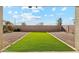 View of backyard with green turf, gravel landscaping, and block wall at 37292 N Yellowstone Dr, San Tan Valley, AZ 85140