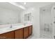 Bright bathroom featuring double sinks, wood cabinets and a tiled floor with a separate toilet at 37292 N Yellowstone Dr, San Tan Valley, AZ 85140