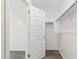 Walk-in closet with door that opens to a bedroom, with wood look floors and shelving at 37292 N Yellowstone Dr, San Tan Valley, AZ 85140