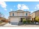 Two-story home featuring a two-car garage, neutral stucco, shuttered windows, and low maintenance landscaping at 37292 N Yellowstone Dr, San Tan Valley, AZ 85140