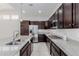 Well-equipped kitchen with granite countertops, stainless steel appliances, and dark wood cabinets at 3868 E Robert St, Gilbert, AZ 85295