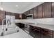 Close-up of kitchen granite countertop, gas cooktop, stainless steel oven and microwave, and custom cabinets at 3868 E Robert St, Gilbert, AZ 85295