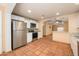 View of kitchen with stainless steel refrigerator and oven, and view to living area at 418 E 3Rd St, Casa Grande, AZ 85122