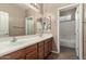 Bathroom features double sinks, a large mirror, and a combined shower and bathtub at 42735 W Bravo Dr, Maricopa, AZ 85138