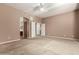 Bright bedroom with carpet flooring, ceiling fan, and access to an ensuite bathroom and walk-in closet at 42735 W Bravo Dr, Maricopa, AZ 85138