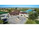 Aerial view of clubhouse with outdoor seating, statues, adjacent to a scenic golf course and pond at 42735 W Bravo Dr, Maricopa, AZ 85138