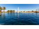 Scenic view of a lake with fountains, surrounded by trees and residential homes on a sunny day at 42735 W Bravo Dr, Maricopa, AZ 85138
