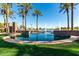 Tranquil community pool with palm trees and water fountains, offering a relaxing oasis for residents at 42735 W Bravo Dr, Maricopa, AZ 85138