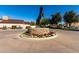 Community statue of a rearing horse surrounded by colorful flowers in a well-maintained roundabout with building in the background at 42735 W Bravo Dr, Maricopa, AZ 85138