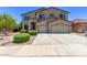 Beautiful two-story home with a three-car garage, manicured bushes, and an inviting driveway at 42735 W Bravo Dr, Maricopa, AZ 85138