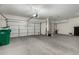 A spacious three car garage with white doors and concrete flooring at 42735 W Bravo Dr, Maricopa, AZ 85138