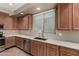Well-lit kitchen with stainless steel dishwasher, sink and wood cabinetry at 42735 W Bravo Dr, Maricopa, AZ 85138