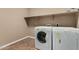 This laundry area includes a white washer and dryer with tile flooring at 42735 W Bravo Dr, Maricopa, AZ 85138