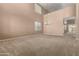 Spacious living room features soaring ceilings, large windows, neutral color palette, and plush carpet at 42735 W Bravo Dr, Maricopa, AZ 85138