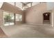 Spacious living room featuring high ceilings, a ceiling fan, and sliding glass doors to backyard at 42735 W Bravo Dr, Maricopa, AZ 85138
