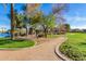 Community park with manicured landscaping, walking path, mature trees, a lake, and ramadas for outdoor gatherings at 42735 W Bravo Dr, Maricopa, AZ 85138