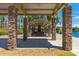 Covered pavilion featuring stone pillars, a fireplace, and picnic tables, ideal for outdoor gatherings by the lake at 42735 W Bravo Dr, Maricopa, AZ 85138